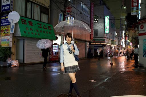 Femme sous la pluie dans les rues de Tokyo avec son parapluie