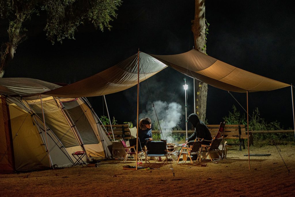 Camping de nuit sous hautvent d'une grande tente.