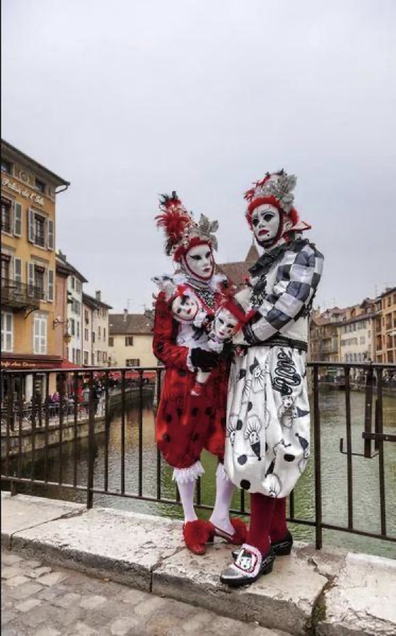 Carnavaliers posant sur l'un des ponts d'Annecy lors du carnaval vénitien.