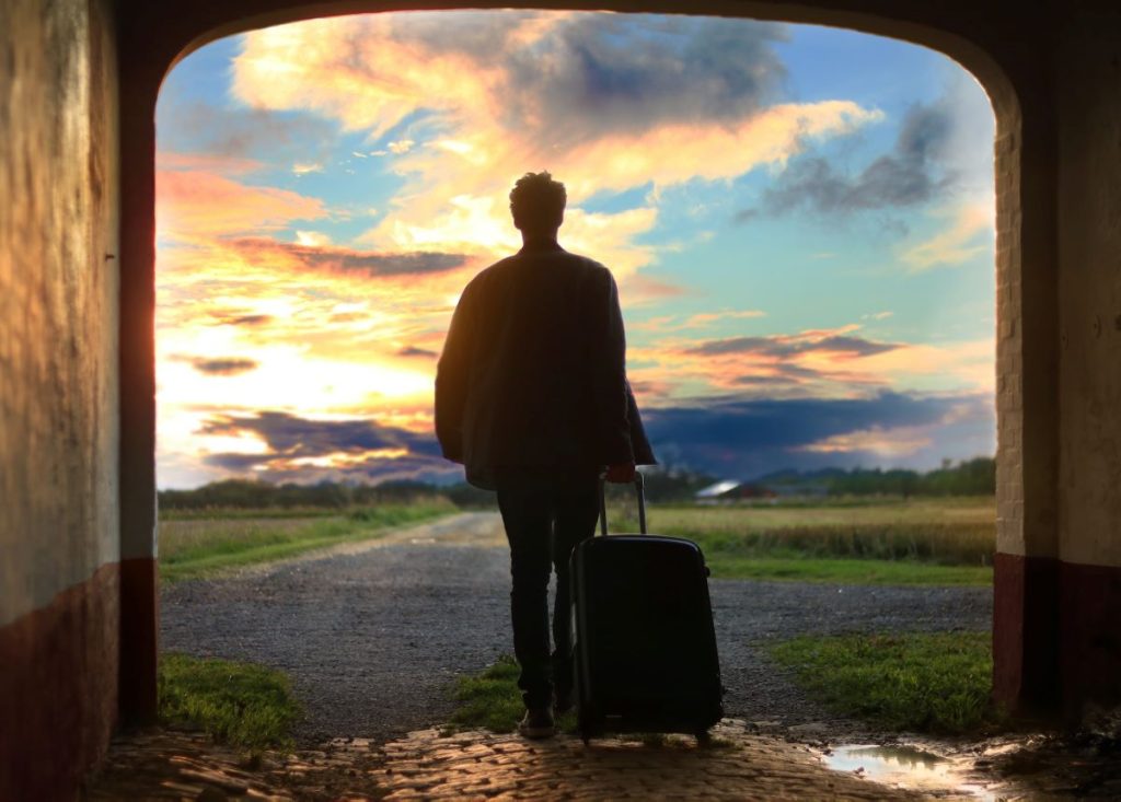 partir en voyage avec valise et coucher de soleil