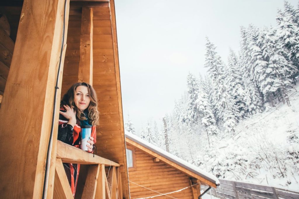 femme sur le balcon d'un appartement de ski